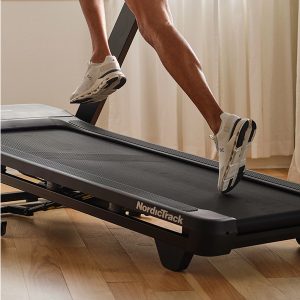 Runner training indoors on a NordicTrack treadmill with advanced treadmill cushioning for joint protection.