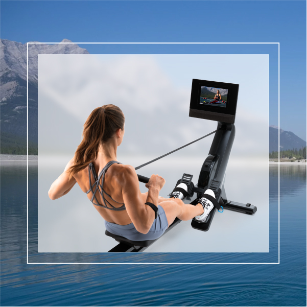 Woman doing a rowing machine workout on a NordicTrack rower with iFIT global training, set against a mountain lake backdrop.